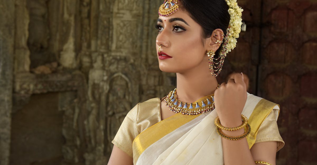 Beautiful Indian woman in traditional saree, adorned with exquisite jewelry, set against historic architecture.
